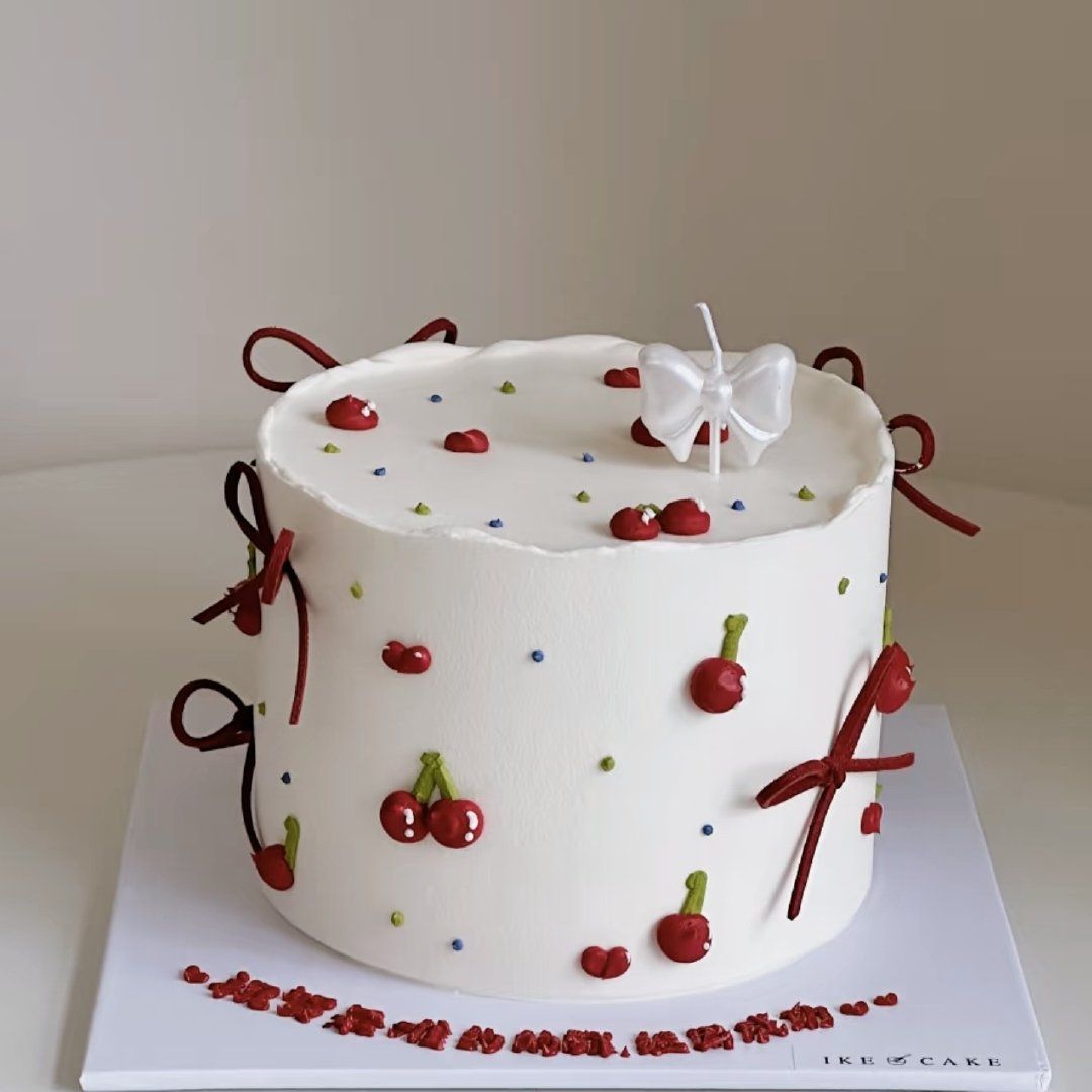 Cake with red cherries and a bow