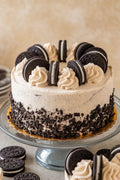 Cookies and Cream cake with Oreo cookies on a glass cake stand.